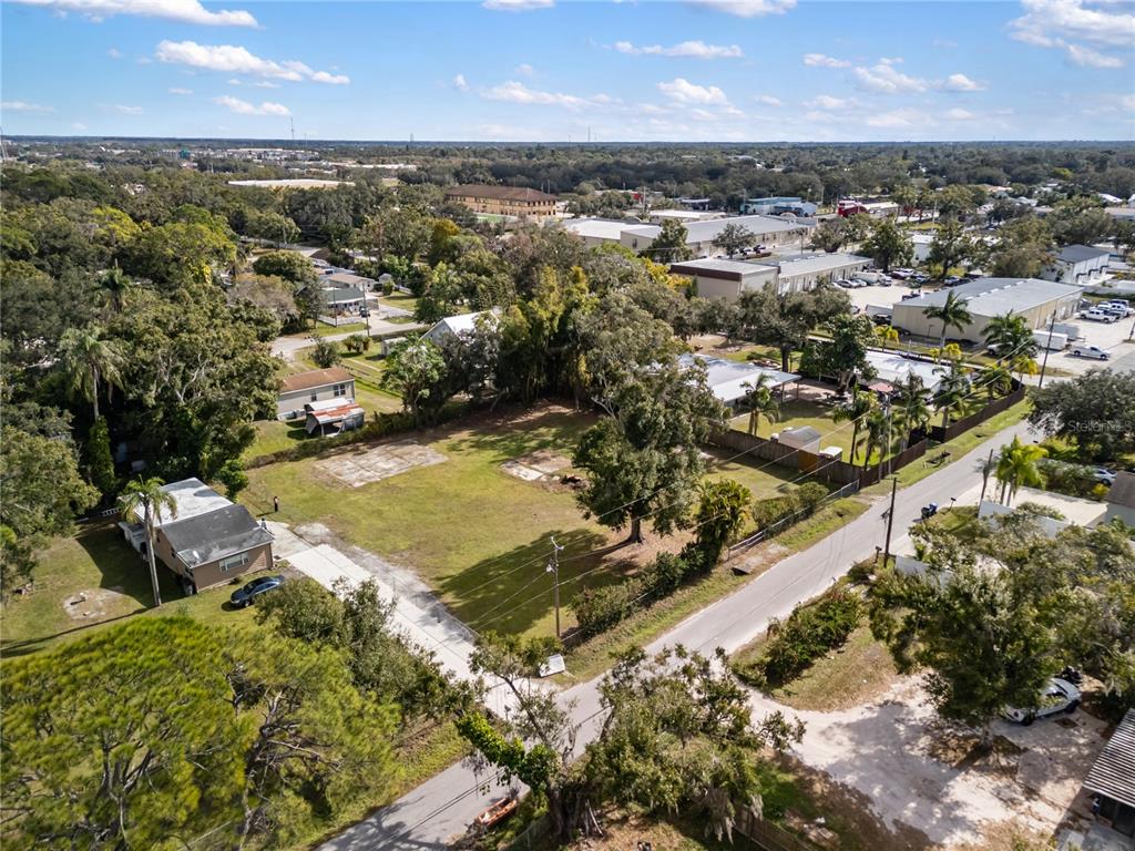 A grassy, sunlit lot features a tree stump and scattered concrete pads under clear skies — 0 HOULE AVENUE, SARASOTA, FL