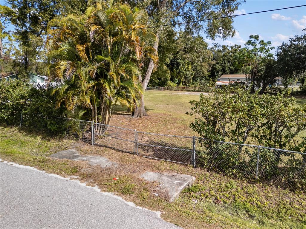 An aerial view shows a vacant lot with concrete pads surrounded by trees and houses — 0 HOULE AVENUE, SARASOTA, FL