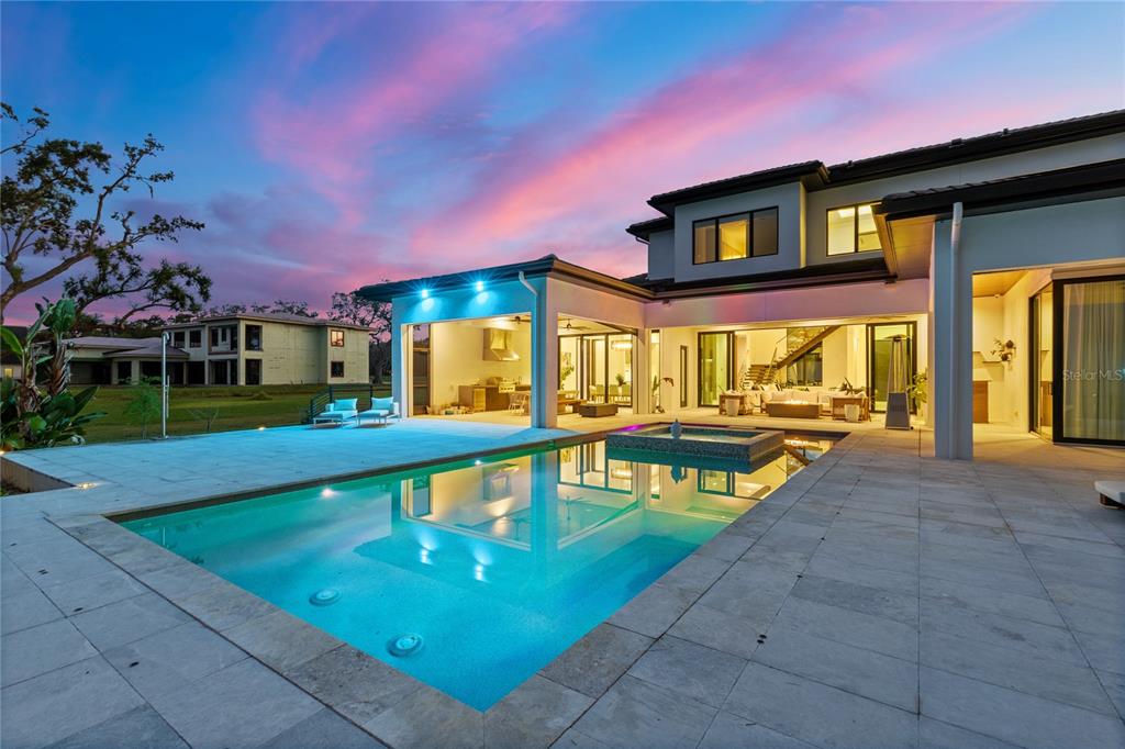 A modern two-story house with a swimming pool and patio at sunset — 13395 KIRBY SMITH ROAD, ORLANDO, FL