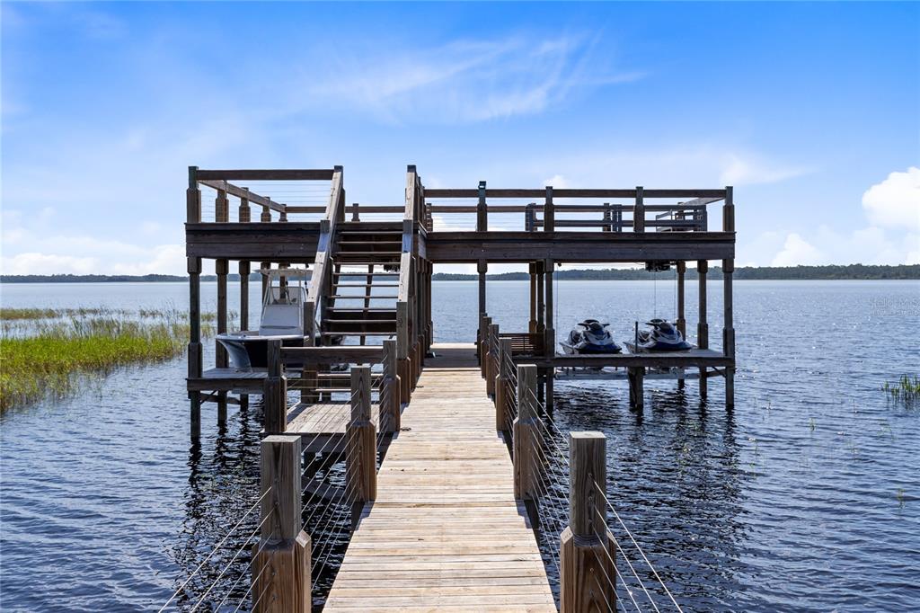 A wooden boat dock with a second-story deck, a boat lift, and two jet skis — 13395 KIRBY SMITH ROAD, ORLANDO, FL