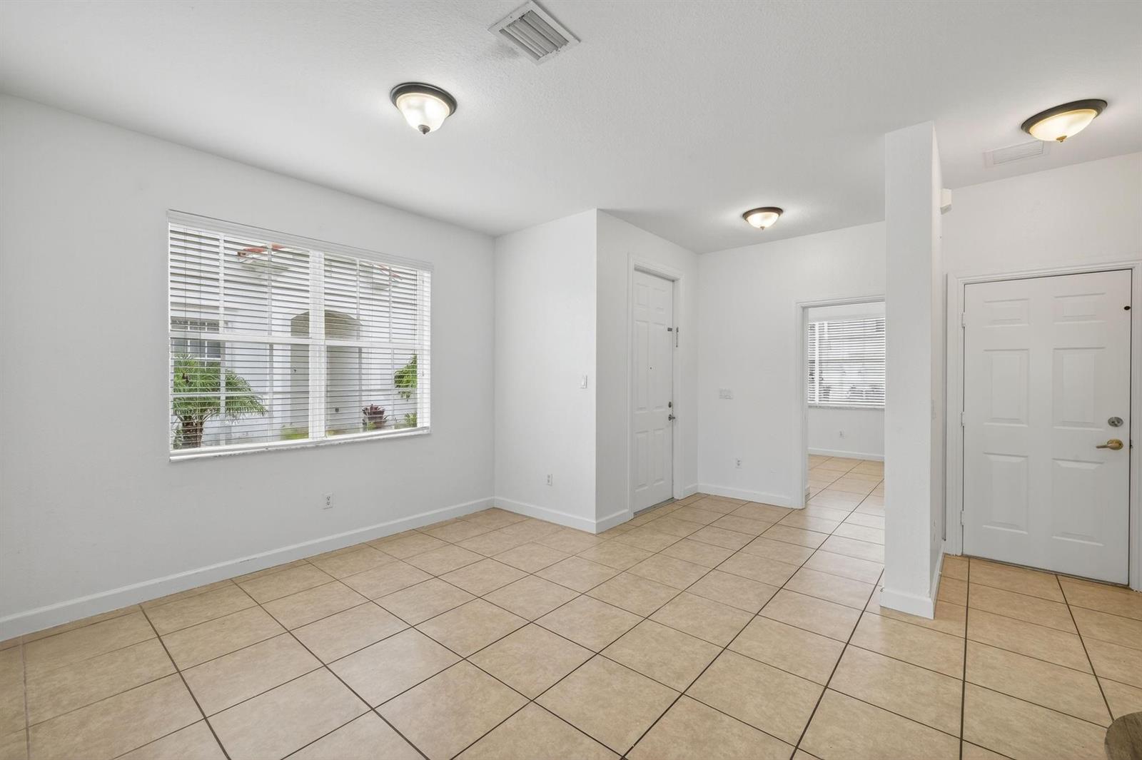 An empty room with beige tile flooring, white walls, and two white doors — 7029 Ambrosia Lane # 606, Naples FL 34119, NAPLES, FL