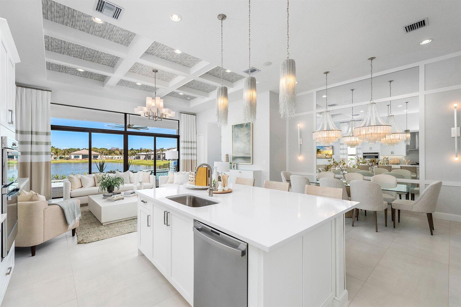 A bright open-concept kitchen and living area with a large island overlooking a lake — 9374 Mountain Pne Grove, Boynton Beach FL 33473, BOYNTON BEACH, FL