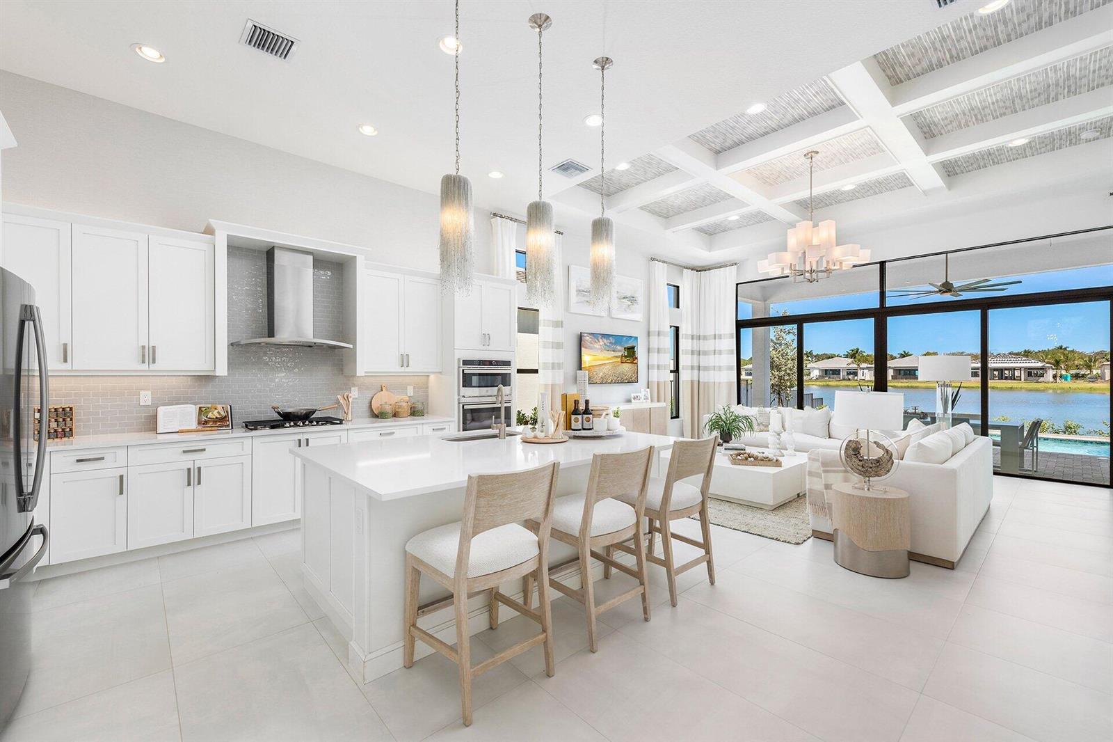 A modern open-concept kitchen and living area with white cabinetry, a large island, and pool — 9374 Mountain Pne Grove, Boynton Beach FL 33473, BOYNTON BEACH, FL