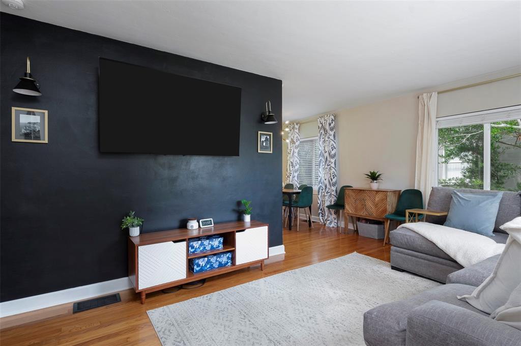 A living room features a black accent wall with a mounted television and wood console — 4332 9TH AVENUE N, ST PETERSBURG, FL