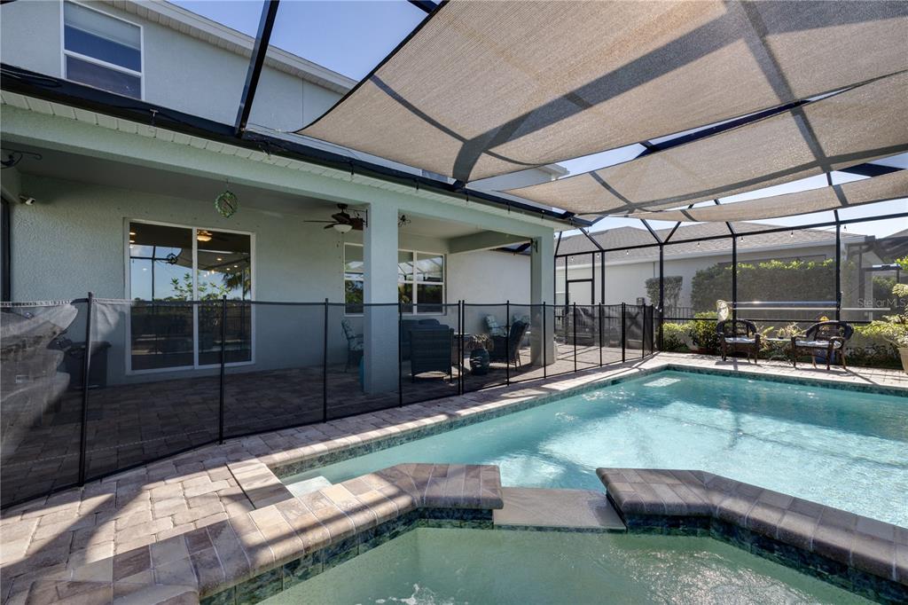 A screened-in patio features a swimming pool, a hot tub, and a mesh safety fence — 17424 SILVERSPUR DRIVE, PUNTA GORDA, FL