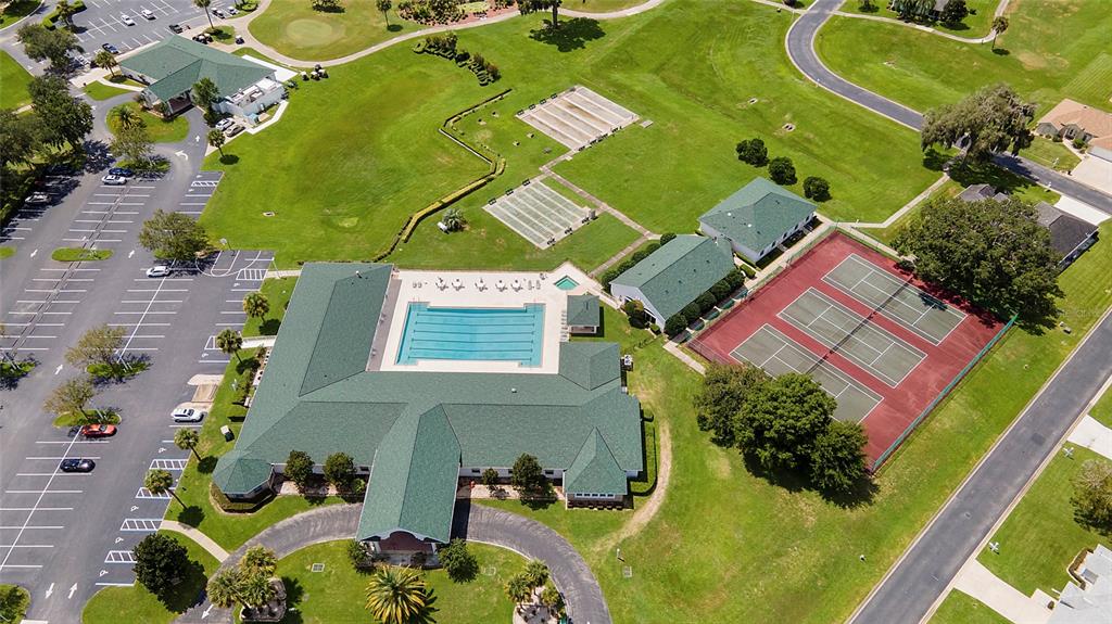 An aerial view shows a clubhouse with a swimming pool and tennis courts — 1921 NW 50TH CIRCLE, OCALA, FL