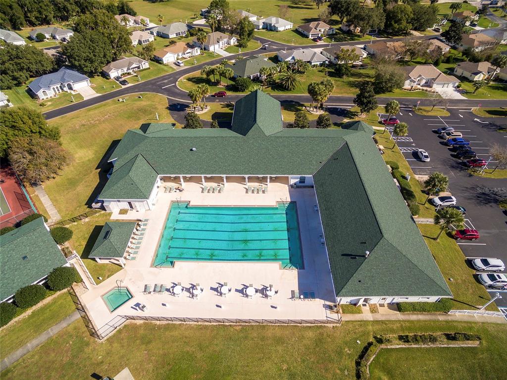 An aerial view shows a community clubhouse with a large swimming pool and parking lot — 1921 NW 50TH CIRCLE, OCALA, FL