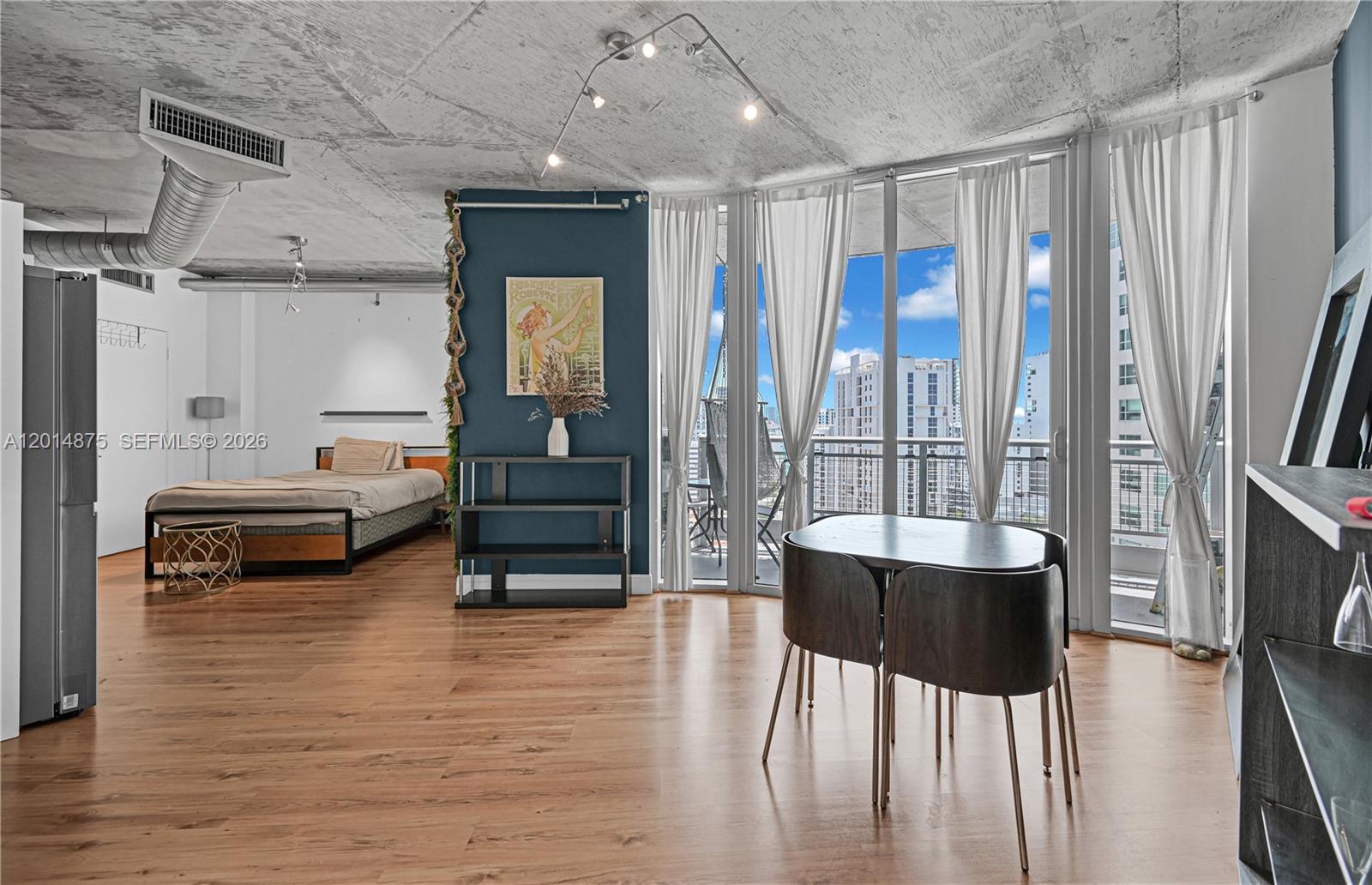This open-concept studio apartment features a concrete ceiling, wood flooring, and a private balcony — 690 SW 1st Ct # 1934, Miami FL 33130, MIAMI, FL