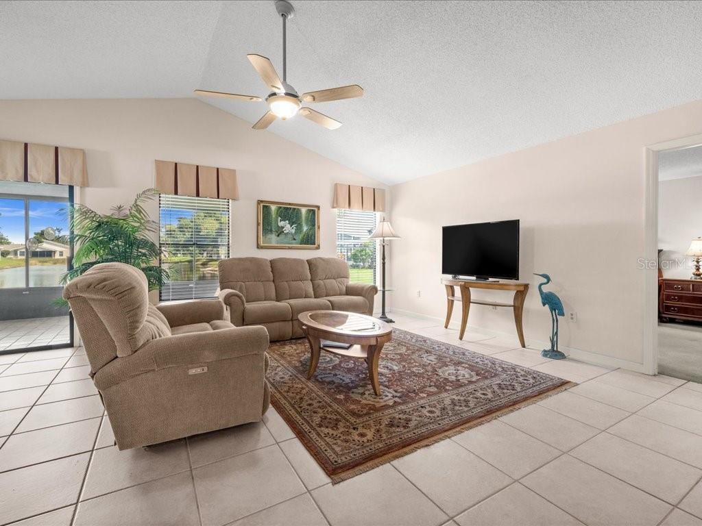 A living room with tile floors, a ceiling fan, a sofa, and a recliner — 411 CYPRESS FOREST DRIVE, ENGLEWOOD, FL