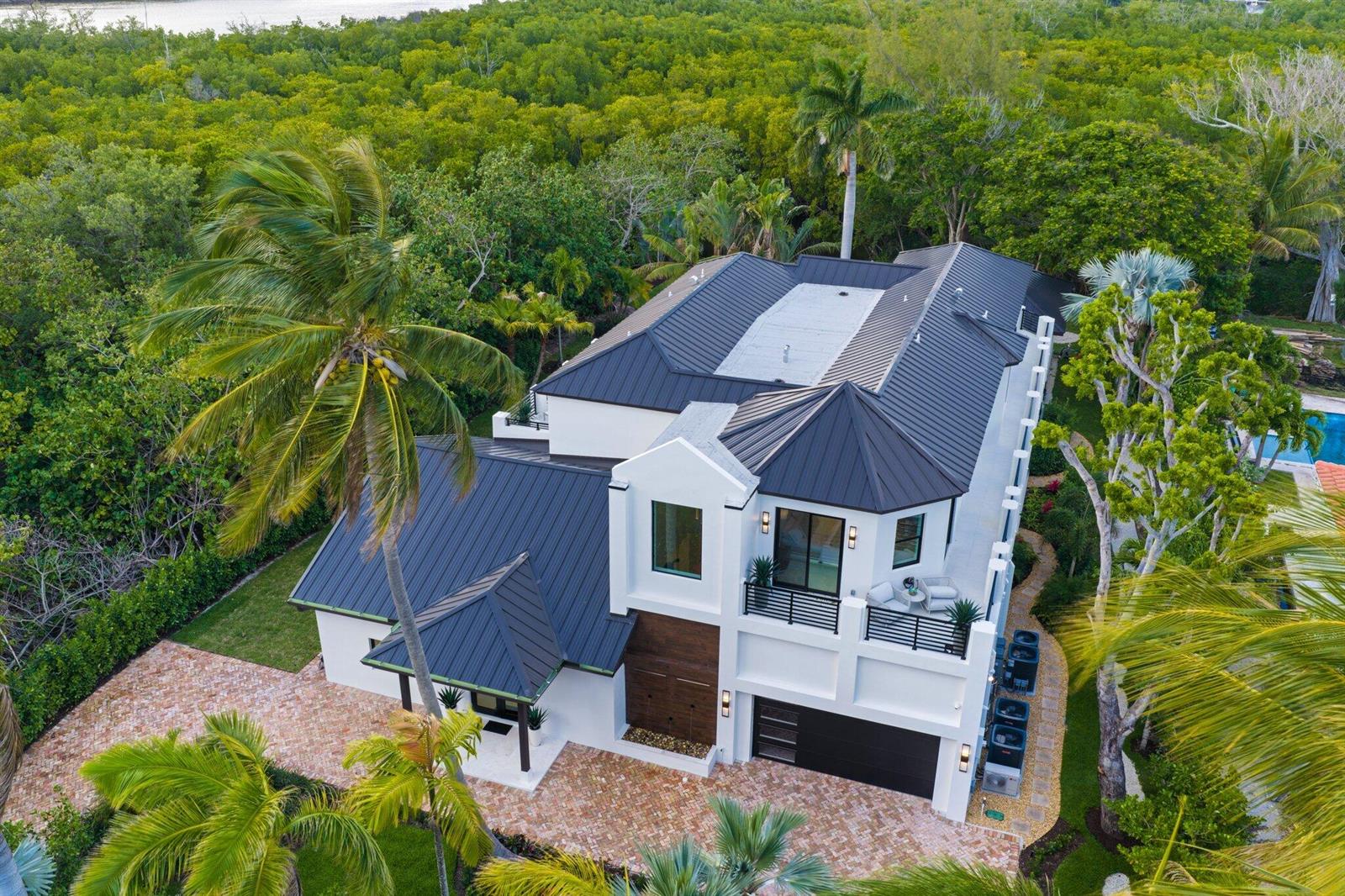 An aerial view of a white two-story house with a dark metal roof and palm trees — 23 Coconut Lane, Ocean Ridge FL 33435, OCEAN RIDGE, FL