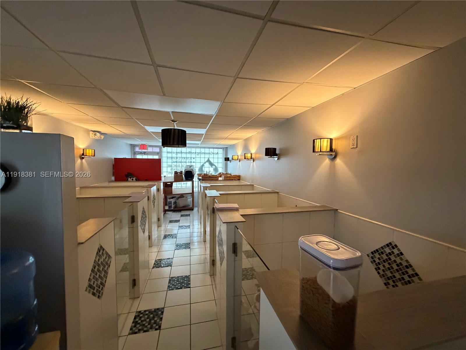 A commercial pet boarding facility features tiled stalls, a drop ceiling, and wall-mounted lighting — SW Bird road, Miami FL 33155, MIAMI, FL