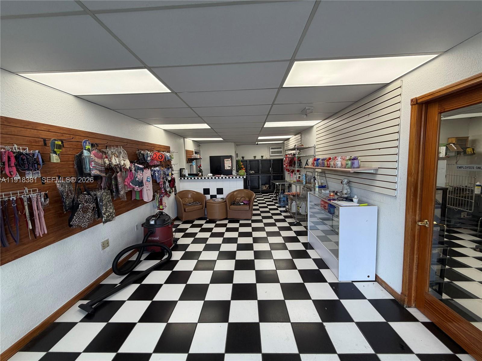 A retail space features a black and white checkered floor, slat walls, and a service counter — SW Bird road, Miami FL 33155, MIAMI, FL