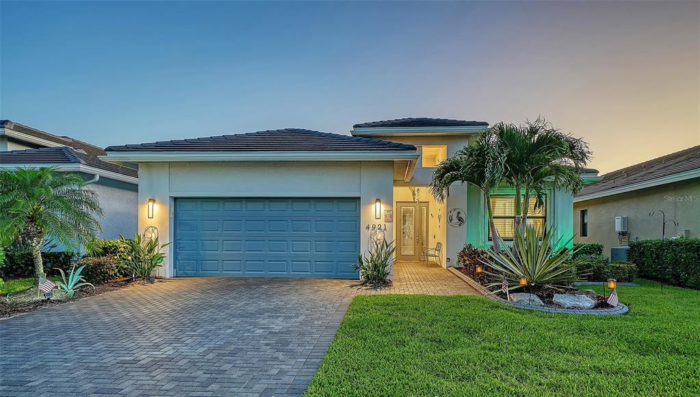 A screened-in patio features a pool, fire pit, and sunset view over a lake — 4921 SURFSIDE CIRCLE, BRADENTON, FL