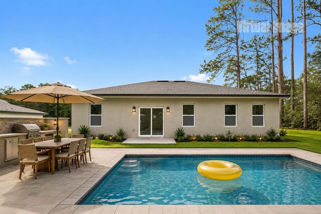 This virtual image shows a backyard with a swimming pool, patio, and outdoor dining area — 1978 W RUTLAND DRIVE, CITRUS SPRINGS, FL