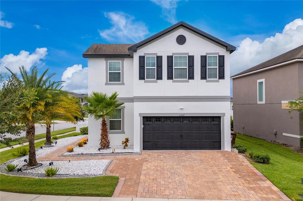 A two-story house with a white exterior, black shutters, and a paved driveway — 2527 NOUVEAU WAY, KISSIMMEE, FL