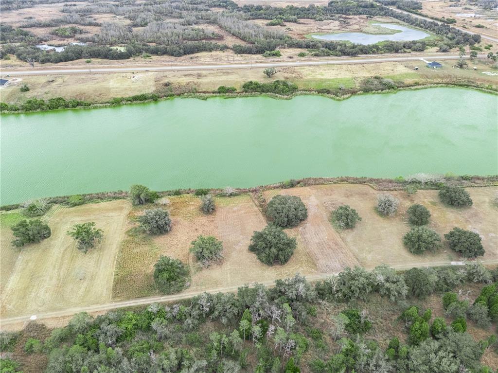 An aerial view shows a green lake bordered by grassy lots with scattered trees — 10349 COUNTY ROAD 555, FORT MEADE, FL