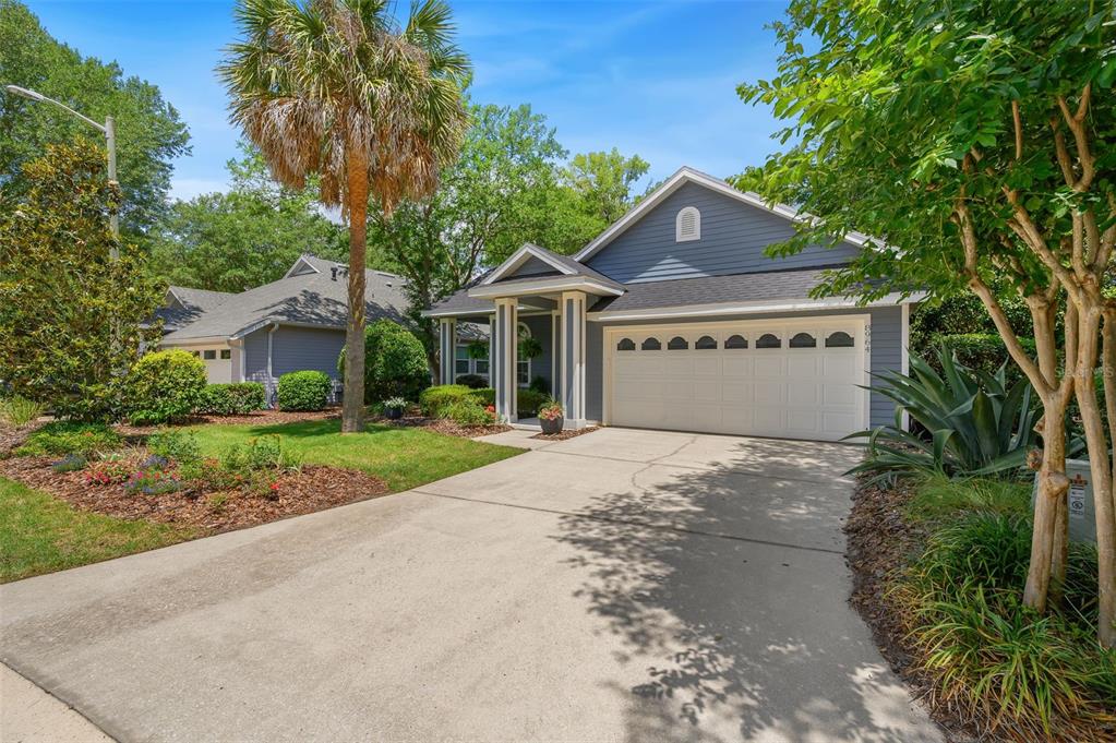 A blue single-story house with a two-car garage and a concrete driveway — 8964 SW 64TH LANE, GAINESVILLE, FL