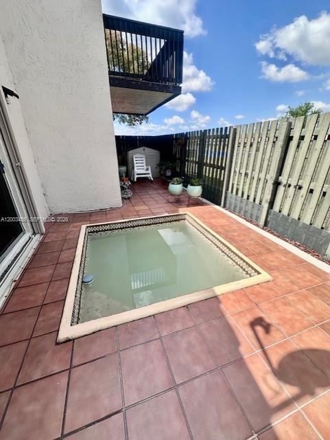 A small square plunge pool sits on a tiled patio next to a wooden fence — 15070 SW 49th Ln # D106, Miami FL 33185, MIAMI, FL