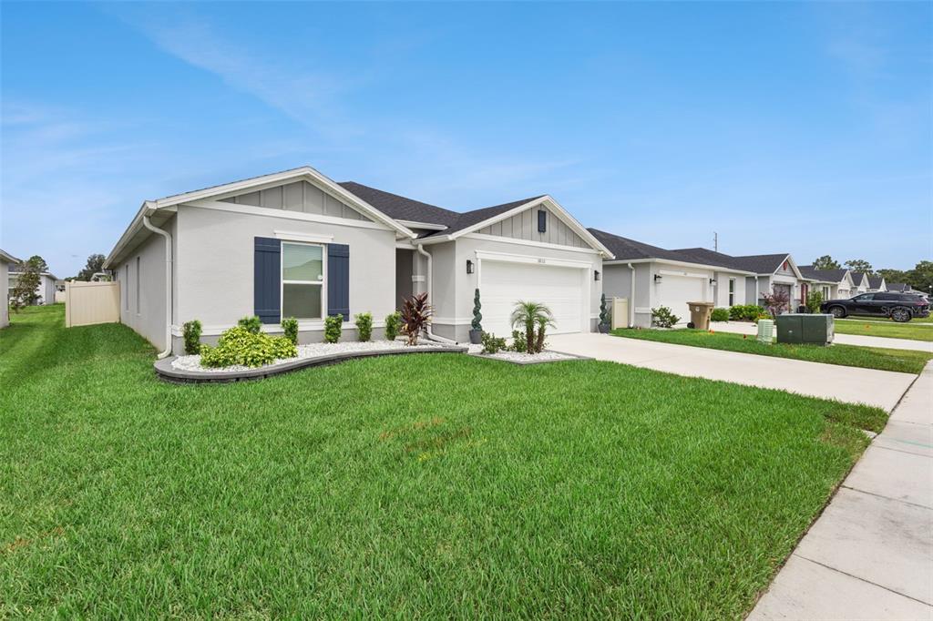 A single-story suburban house with a gray exterior, dark shutters, and a two-car garage — 3832 PRONGHORN DR, ST CLOUD, FL