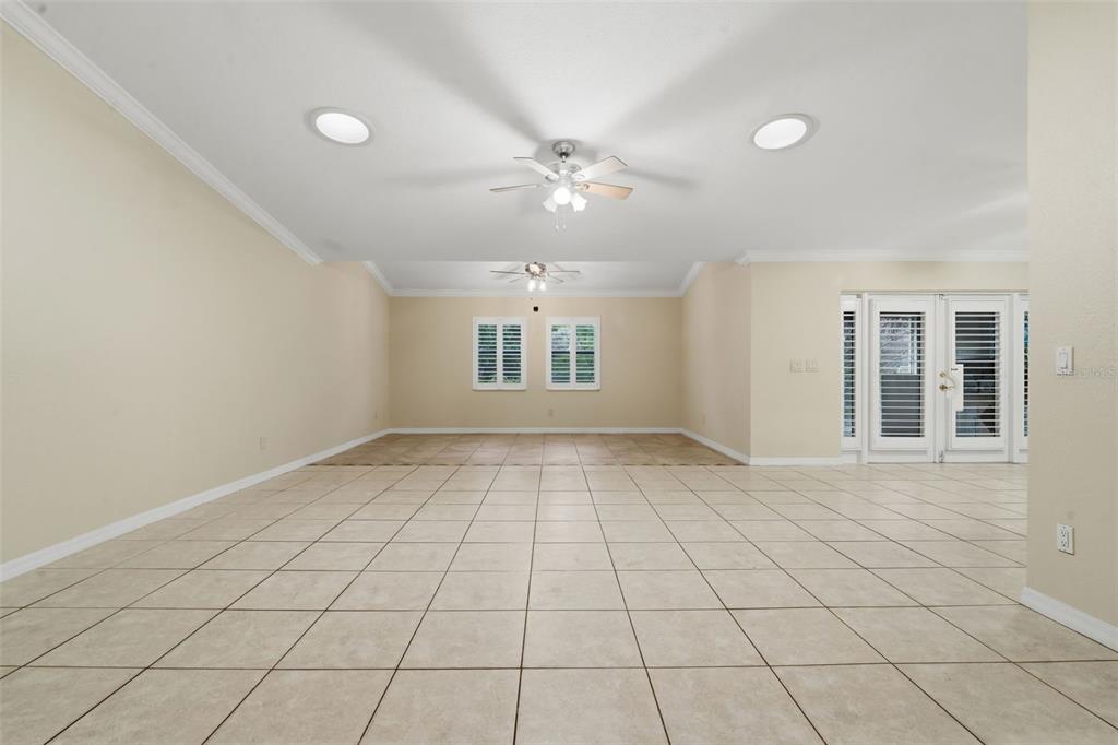 A spacious, tiled living room features a vaulted ceiling with two ceiling fans and recessed lighting — 8423 BERMUDA DUNES DRIVE, ORLANDO, FL