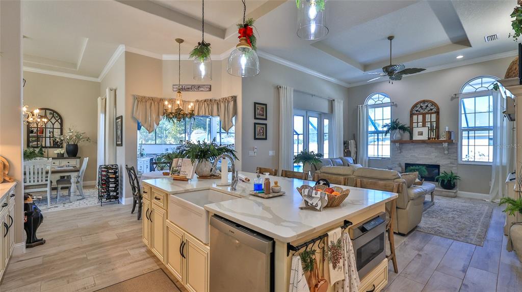 A kitchen with a large island and farmhouse sink overlooks an open-concept living room — 1 ROCKWELL LANE, PALM COAST, FL