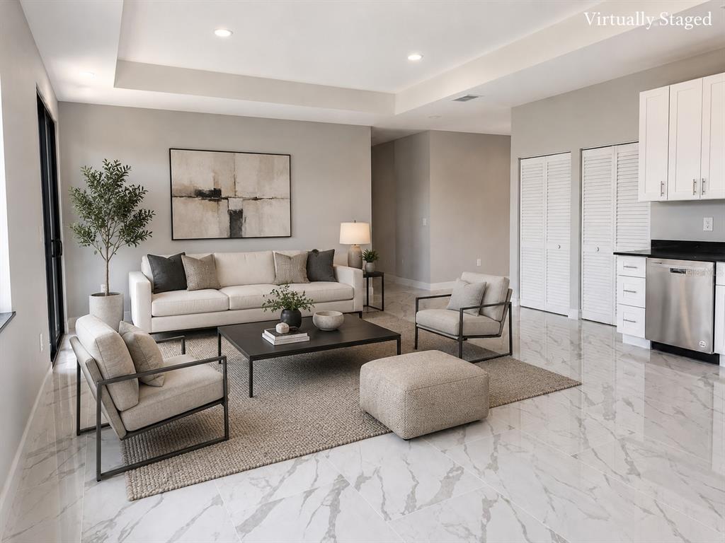 A living room with white tile floors, a sofa, two armchairs, and a coffee table — 1610 NE 34TH STREET, CAPE CORAL, FL