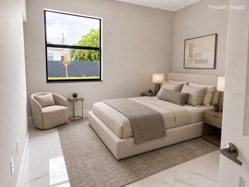 A virtually staged bedroom features a bed, armchair, and window overlooking a fenced yard — 1610 NE 34TH STREET, CAPE CORAL, FL