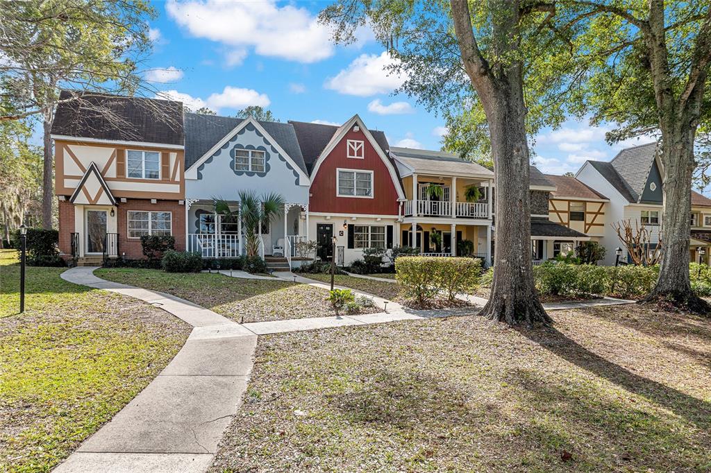A row of multi-story townhomes with varied architectural styles and exterior colors — 9951 SW 88TH COURT ROAD UNIT C, OCALA, FL