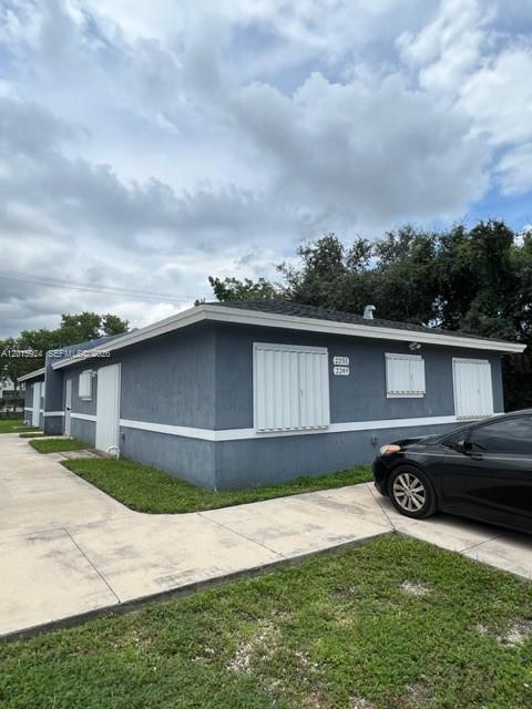 A gray single-story building with white trim and accordion shutters on the windows — 2249 NW 66th St # 2249, Miami FL 33147, MIAMI, FL