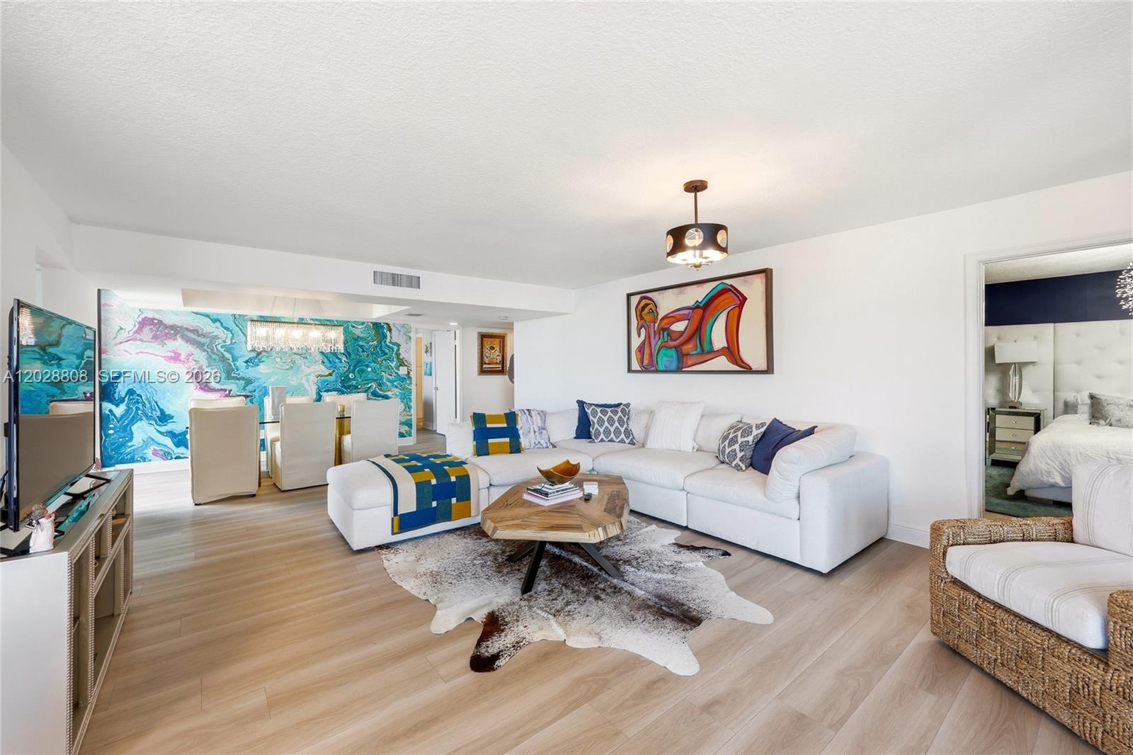 A living room features a white sectional sofa, a cowhide rug, and a colorful accent wall — 5380 N Ocean Dr # 18B, Singer Island FL 33404, SINGER ISLAND, FL