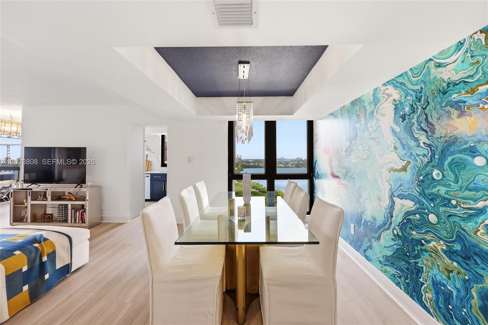 A dining room features a glass table, white chairs, a blue tray ceiling, and mural — 5380 N Ocean Dr # 18B, Singer Island FL 33404, SINGER ISLAND, FL