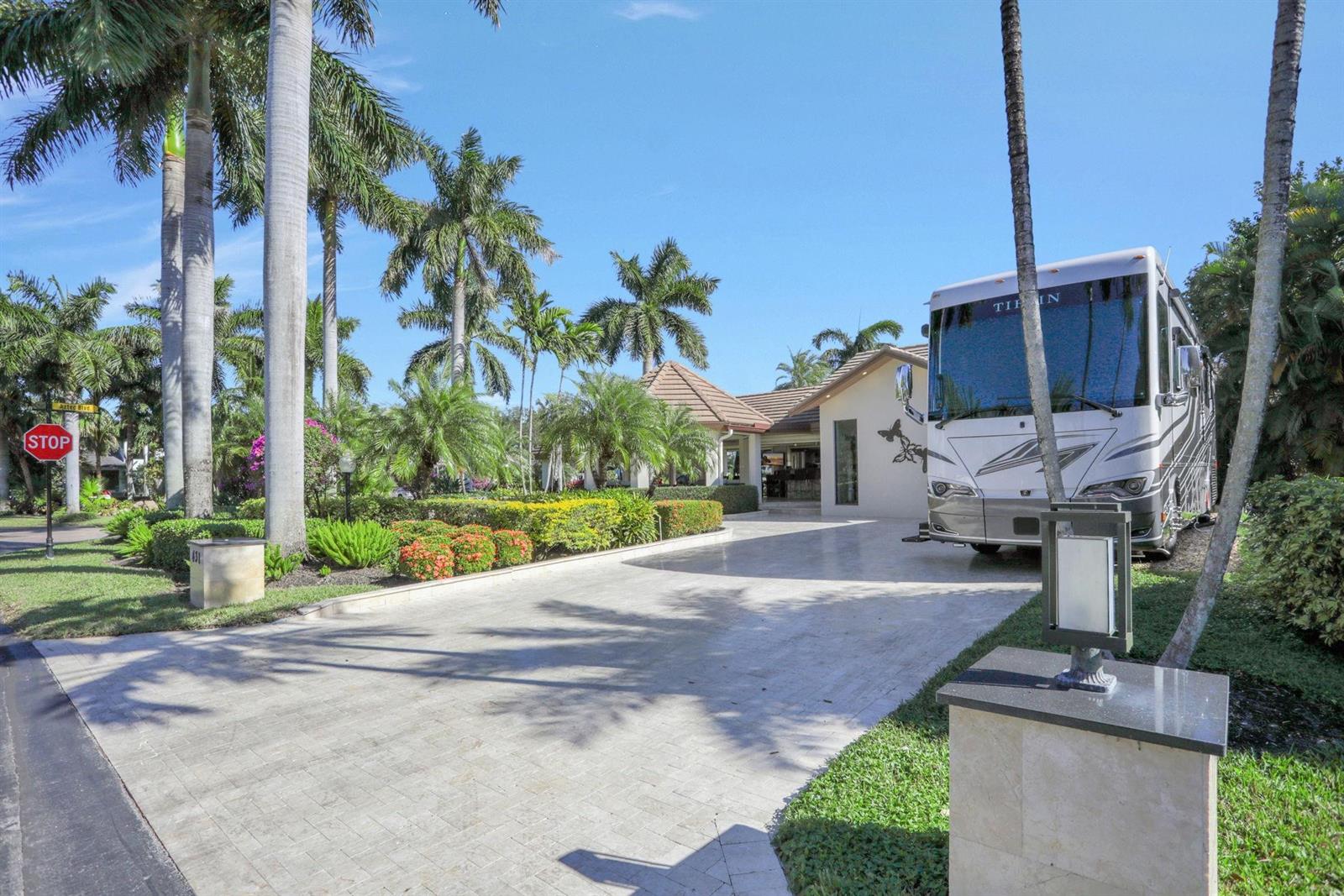 A large recreational vehicle is parked on the paved driveway of a tropical residential property — 431 S Cortez Drive # 431, Margate FL 33068, MARGATE, FL