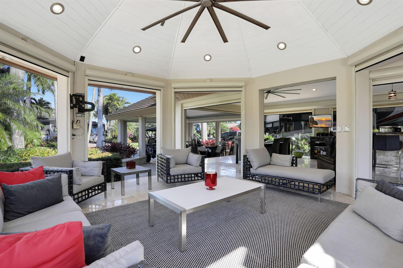 A bright, open-air patio features modern lounge furniture, a white coffee table, and ceiling fans — 431 S Cortez Drive # 431, Margate FL 33068, MARGATE, FL