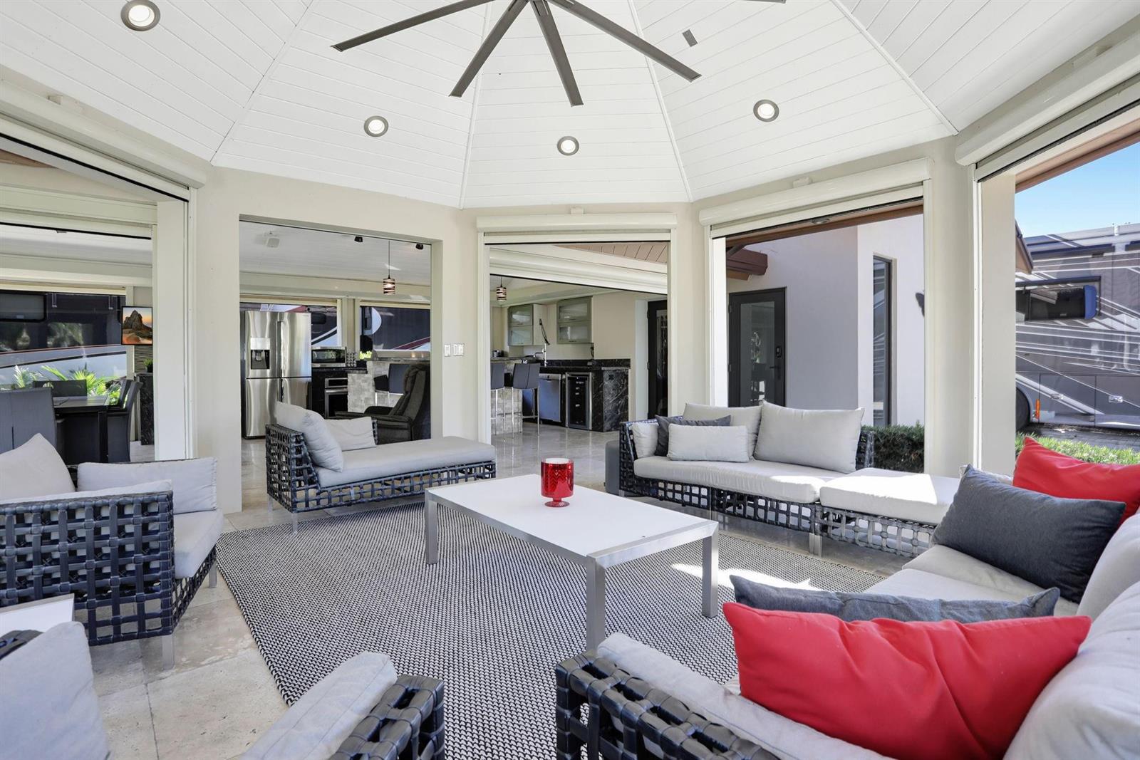 An open-air patio features a white vaulted ceiling, modern outdoor furniture, and a central coffee table — 431 S Cortez Drive # 431, Margate FL 33068, MARGATE, FL