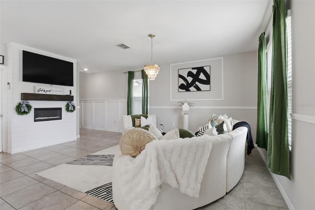 A living room features a white fireplace, a curved sofa, and green curtains — 17032 YELLOW PINE STREET, WIMAUMA, FL