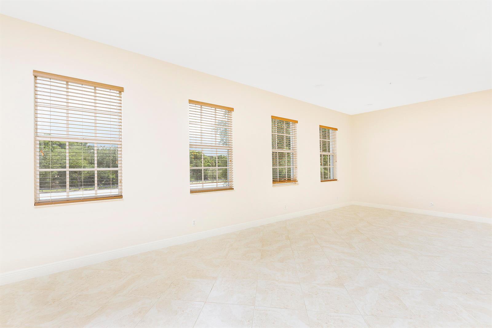 An empty room with light-colored tile flooring and four windows with wooden blinds — 6807 Lakeside Circle N # 1, Davie FL 33314, DAVIE, FL