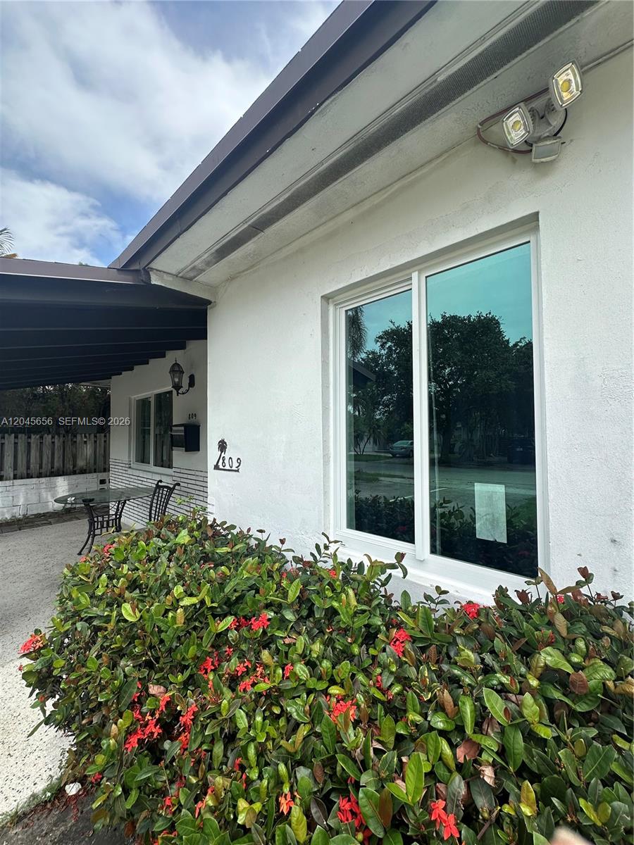 A white exterior wall features a large window, a house number, and a landscaped garden — 809 NE 2nd St unit 1-2, Hallandale Beach FL 33009, HALLANDALE BEACH, FL