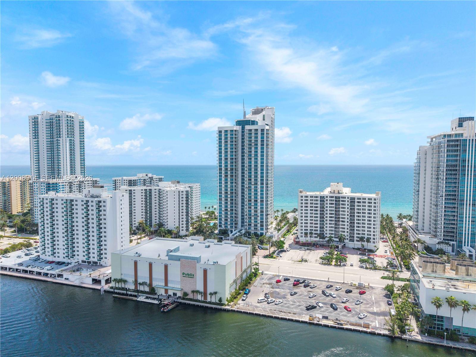 An aerial view shows a Publix supermarket, parking lot, and several high-rise buildings near water — 3101 S Ocean Dr # 2705, Hollywood FL 33019, HOLLYWOOD, FL