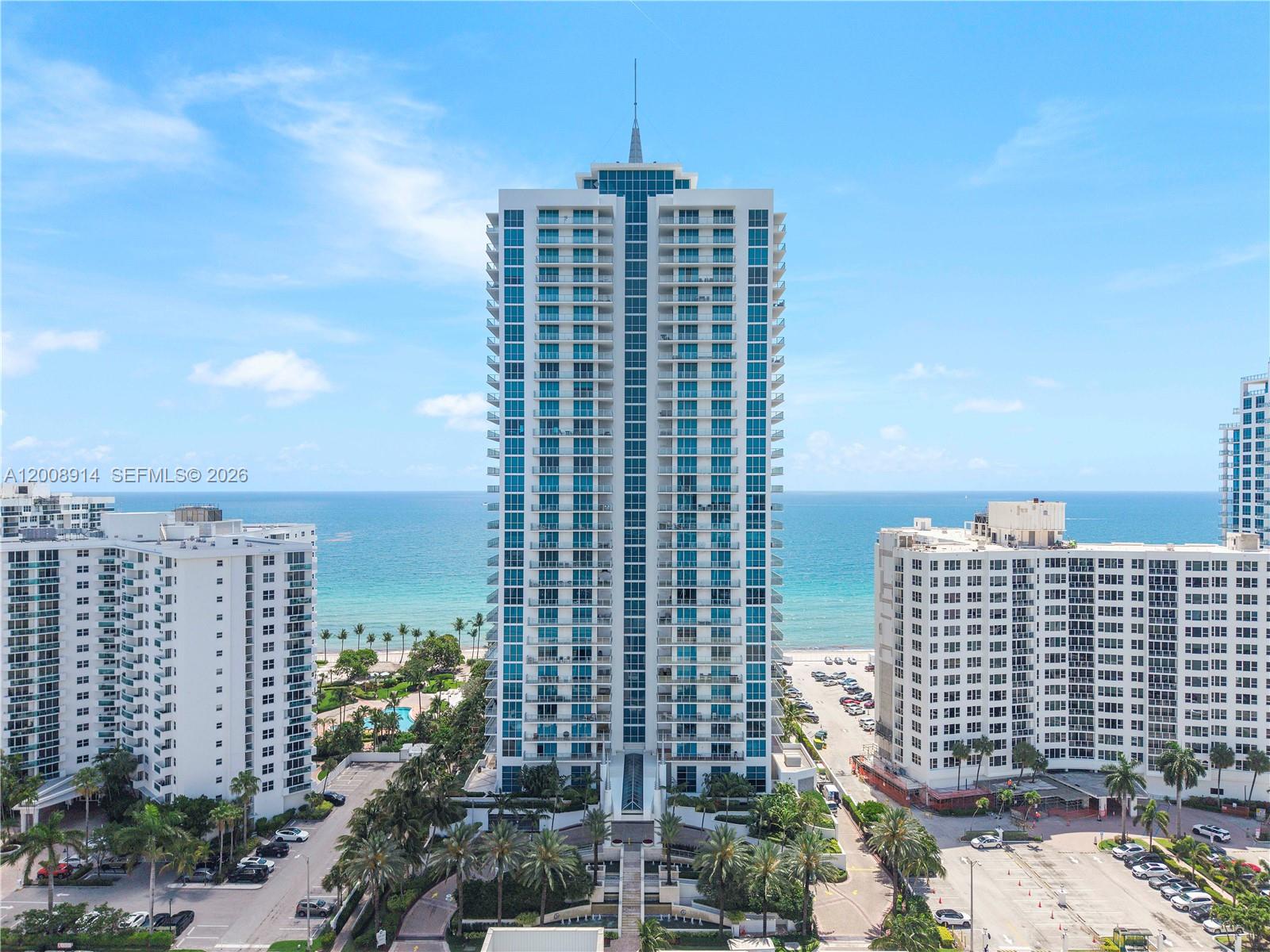 A tall residential high-rise building stands between two other apartment complexes near the ocean — 3101 S Ocean Dr # 2705, Hollywood FL 33019, HOLLYWOOD, FL