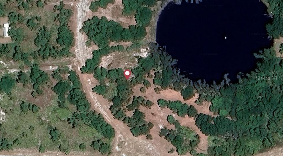 This is an aerial view of a wooded lot next to a lake — 12516 FIESTA CIRCLE, PUNTA GORDA, FL