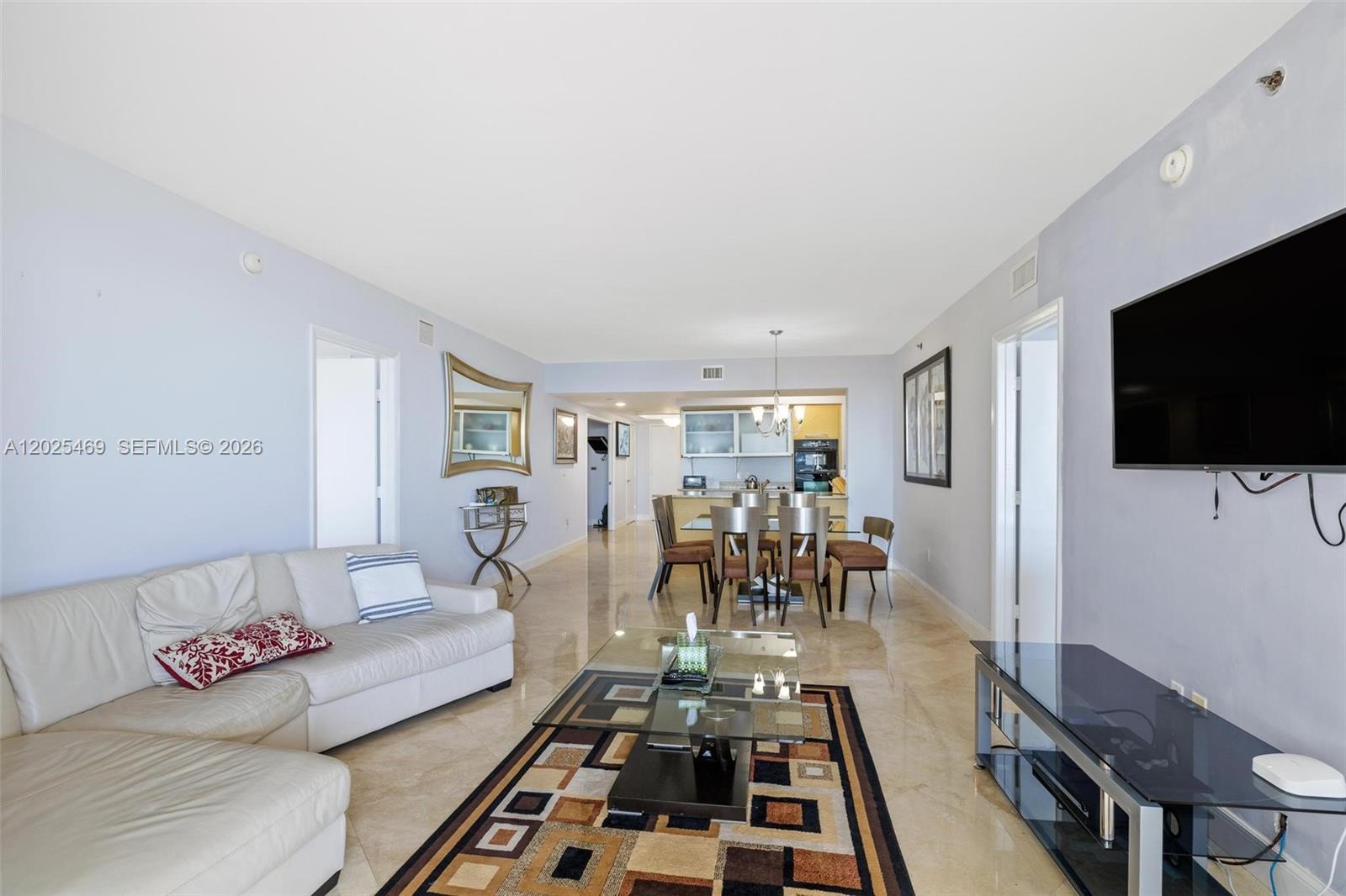 A living room with a white sectional sofa, glass coffee table, and adjacent dining area — 1830 S Ocean Dr # 2804, Hallandale Beach FL 33009, HALLANDALE BEACH, FL