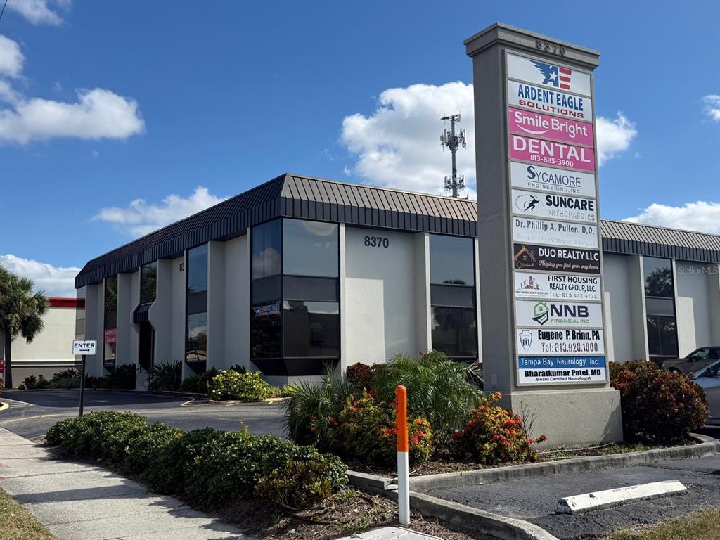 A multi-tenant commercial office building with a prominent directory sign in the foreground — 8370 W HILLSBOROUGH AVENUE UNIT 206, TAMPA, FL