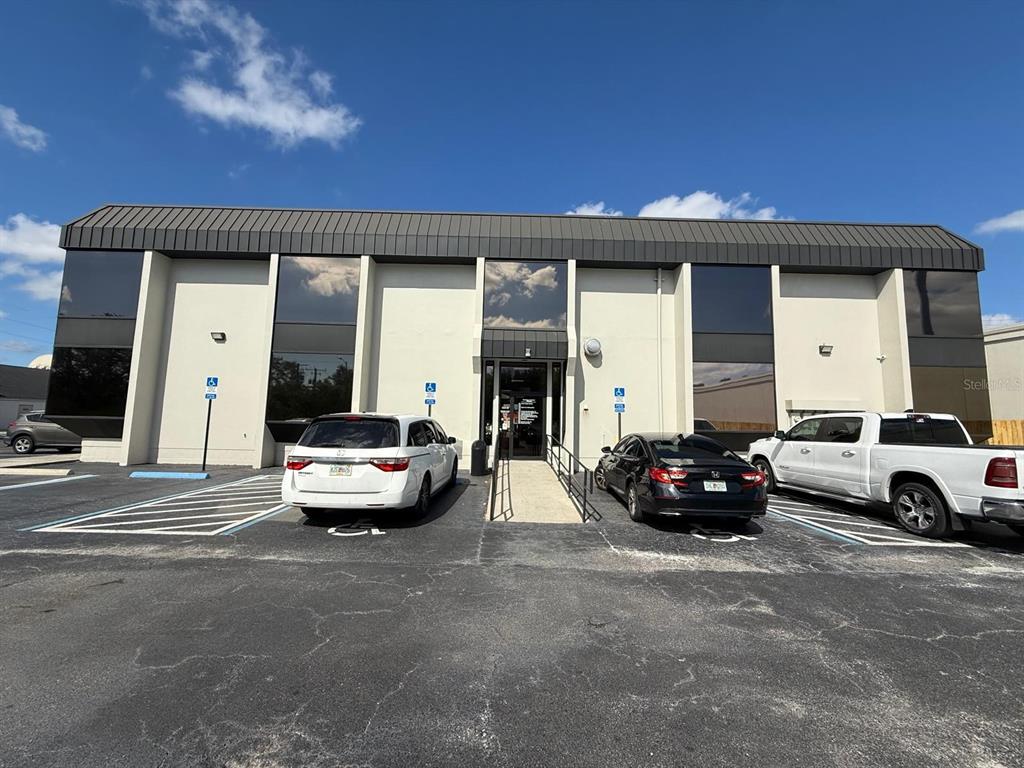 A two-story commercial building with a dark metal roof and a central entrance ramp — 8370 W HILLSBOROUGH AVENUE UNIT 206, TAMPA, FL