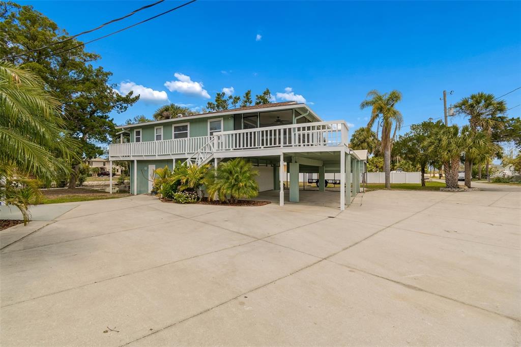 A single-story house with a concrete driveway, a wheelchair ramp, and palm trees in front — 14539 COFFEY LANE, HUDSON, FL