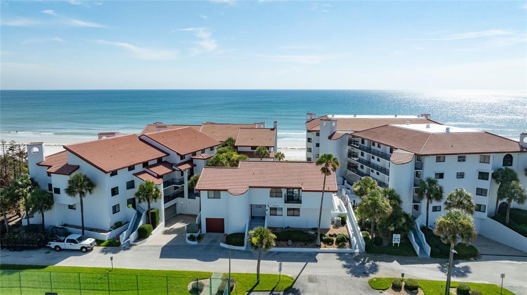 An aerial view of a multi-story beachfront condominium complex with red tile roofs — 3001 S ATLANTIC AVENUE UNIT 433, NEW SMYRNA BEACH, FL
