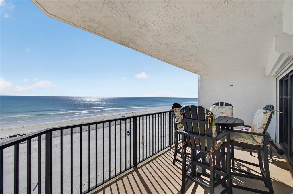 A balcony with a black metal railing overlooks a sandy beach and the ocean — 3001 S ATLANTIC AVENUE UNIT 433, NEW SMYRNA BEACH, FL