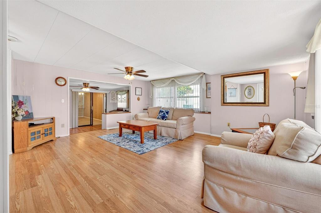 A living room with light wood floors, beige furniture, and a ceiling fan — 31643 HOWARD STREET, TAVARES, FL