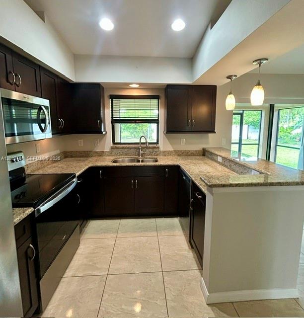 A kitchen features dark wood cabinets, granite countertops, stainless steel appliances, and tile flooring — 20 NE 20th Ave, Cape Coral FL 33909, CAPE CORAL, FL