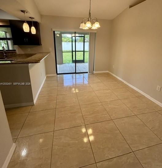 A dining area with beige tile flooring, a chandelier, and a sliding glass door — 20 NE 20th Ave, Cape Coral FL 33909, CAPE CORAL, FL