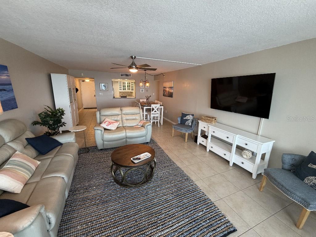 A living room features a beige sofa, a round coffee table, and a wall-mounted television — 17920 GULF BOULEVARD UNIT 803, REDINGTON SHORES, FL